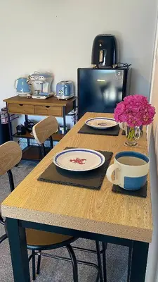 a wooden table with plates and flowers on it at Sea view Studio by Fistral Beach in Newquay
