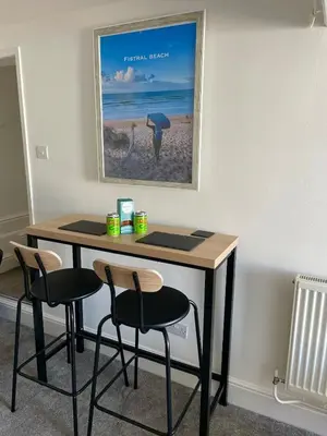 a table with two chairs and a picture of the beach at Sea view Studio by Fistral Beach in Newquay