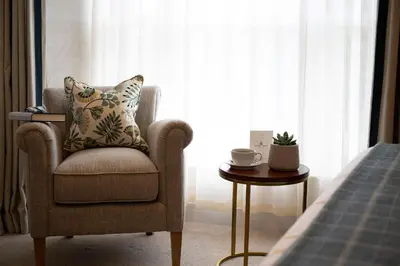 a chair and a table in a room with a window at Basset Arms, Portreath, Cornwall in Portreath
