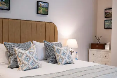 a bedroom with a bed with blue and white pillows at Basset Arms, Portreath, Cornwall in Portreath