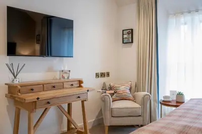a bedroom with a bed and a dresser and a chair at Basset Arms, Portreath, Cornwall in Portreath