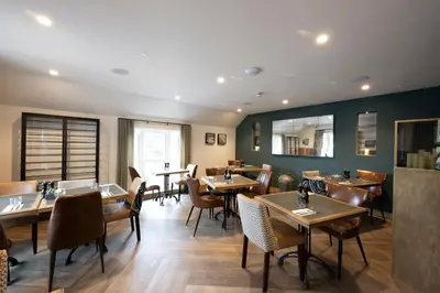 a dining room with wooden tables and chairs at Basset Arms, Portreath, Cornwall in Portreath