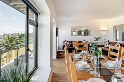 a dining room with a table and a balcony at 4 Bed in St. Ives oc-c28788 in St Ives