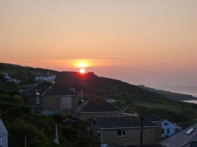 a sunset over a town with houses and the ocean at 4 Bed in St. Ives oc-c28788 in St Ives