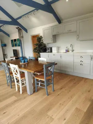 a large kitchen with a wooden table and chairs at Ocean Heart Studio- Luxury, Rural Retreat in Wendron