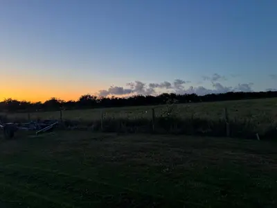 a sunset in a field with a fence at Ocean Heart Studio- Luxury, Rural Retreat in Wendron