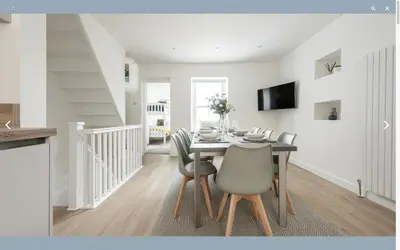 a dining room with a table and chairs at VITAMYN SEA, 4 bedroom house, Sleeps 8, 6 beds, Sea views, 5 min walk to harbour and beaches in St Ives