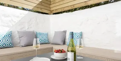 a table with two glasses of wine and a bowl of fruit at VITAMYN SEA, 4 bedroom house, Sleeps 8, 6 beds, Sea views, 5 min walk to harbour and beaches in St Ives
