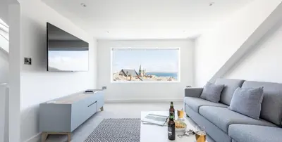 a living room with a couch and a table at VITAMYN SEA, 4 bedroom house, Sleeps 8, 6 beds, Sea views, 5 min walk to harbour and beaches in St Ives