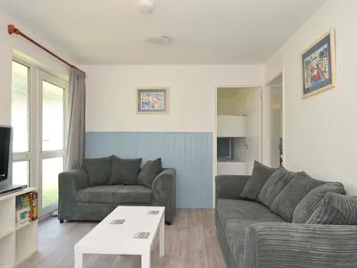 a living room with a couch and a table at 4 Rosecraddoc Lodge Holiday Bungalows in Liskeard