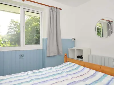 a bedroom with a bed and a window at 4 Rosecraddoc Lodge Holiday Bungalows in Liskeard