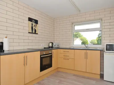 a kitchen with wooden cabinets and a window at 4 Rosecraddoc Lodge Holiday Bungalows in Liskeard