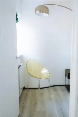 a yellow chair sitting in a room next to a wall at Merthen House in Falmouth