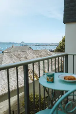 a table with a plate of food on a balcony at Merthen House in Falmouth