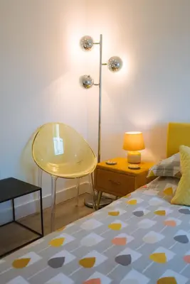 a bedroom with a bed and a table and a lamp at Merthen House in Falmouth