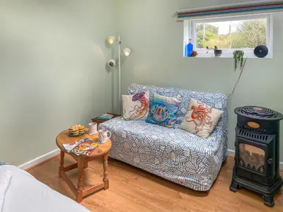 a living room with a couch and a stove at Gwennel Nook in St. Agnes
