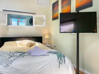 a bedroom with a bed with a flat screen tv at Gwennel Nook in St. Agnes