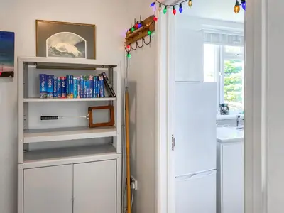 a kitchen with white cabinets and a door at Gwennel Nook in St. Agnes