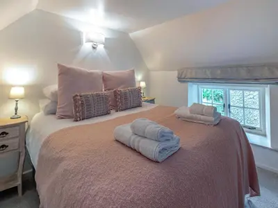 a bedroom with a large bed with two towels on it at Penda in Porthscatho