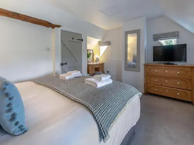 a bedroom with a large bed with towels on it at Penda in Porthscatho