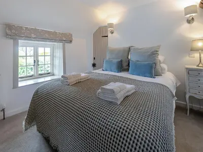 a bedroom with a large bed with towels on it at Penda in Porthscatho