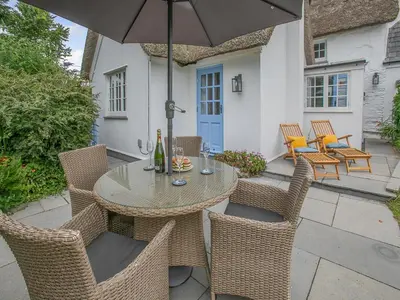 a table and chairs with an umbrella on a patio at Penda in Porthscatho