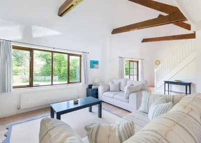 a living room with a white couch and a table at Idle Rock in Polzeath