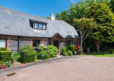 a brick house with a driveway in front of it at Idle Rock in Polzeath