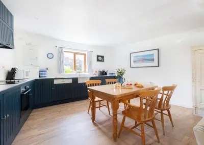 a kitchen and dining room with a table and chairs at Idle Rock in Polzeath