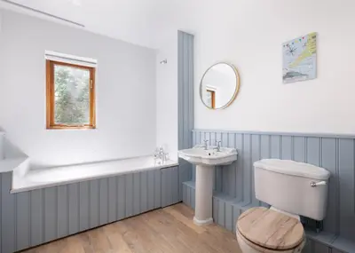 a bathroom with a tub and a sink and a toilet at Idle Rock in Polzeath