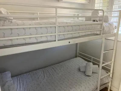 two bunk beds in a small room with a mattress at 'The Dunes', Porthtowan in Porthtowan