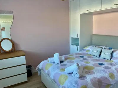 a bedroom with a bed with a dresser and a mirror at 'The Dunes', Porthtowan in Porthtowan