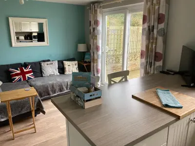 a living room with a couch and a table at 'The Dunes', Porthtowan in Porthtowan
