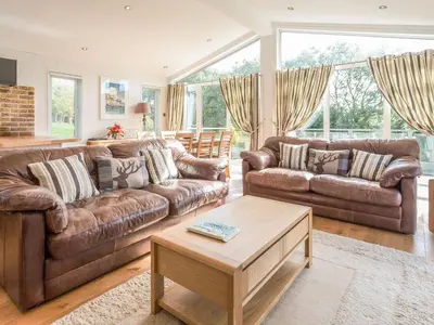 a living room with two leather couches and a coffee table at 2 Tree Tops in Looe