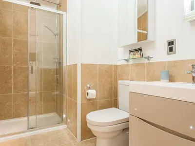a bathroom with a shower and a toilet and a sink at 2 Tree Tops in Looe