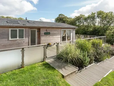 a house with a wooden walkway in front of it at 2 Tree Tops in Looe