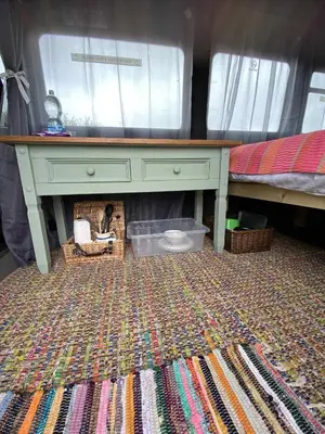 a desk in a room with a bed and a rug at Quiet peaceful relaxing off grid Campervan Seaview and Ponies in Carbis Bay