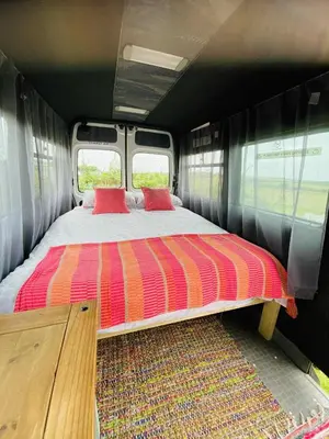 a bed in the inside of a train car at Quiet peaceful relaxing off grid Campervan Seaview and Ponies in Carbis Bay