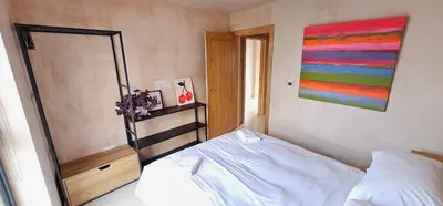 a bedroom with a bed and a painting on the wall at Shorebreak Apartment 2 in Newquay