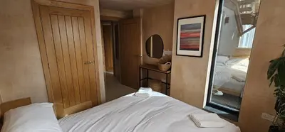 a small room with a bed and a mirror at Shorebreak Apartment 2 in Newquay