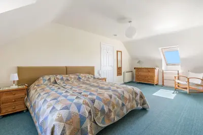 a bedroom with a bed and a table and a chair at Gully at Highcliffe in Polzeath