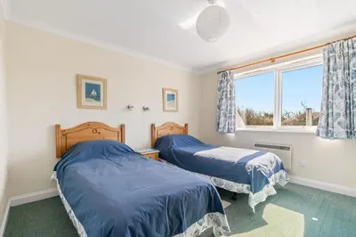 two beds in a room with a window at Gully at Highcliffe in Polzeath
