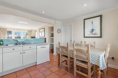 a kitchen and dining room with a table and chairs at Gully at Highcliffe in Polzeath