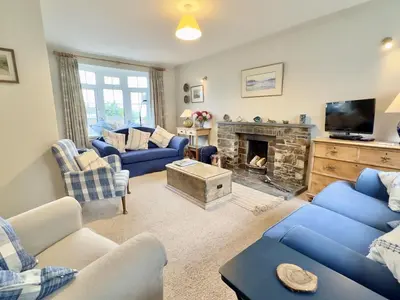 a living room with blue couches and a fireplace at Choughs in Saint Minver