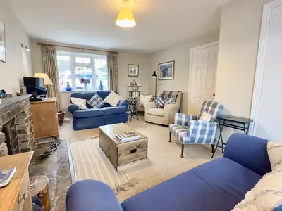 a living room with blue couches and chairs at Choughs in Saint Minver
