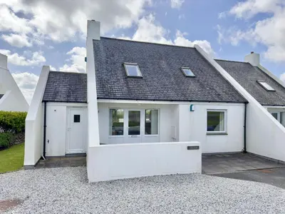 a white house with a garage at Chough at Highcliffe in Polzeath