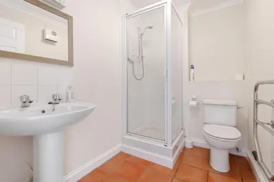 a bathroom with a shower and a toilet and a sink at Chough at Highcliffe in Polzeath