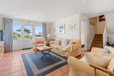 a living room with couches and a table at Chough at Highcliffe in Polzeath