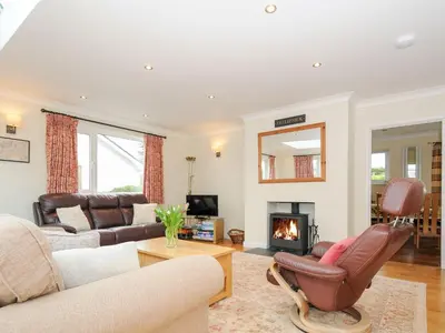 a living room with a couch and a fireplace at Chimings in Wadebridge