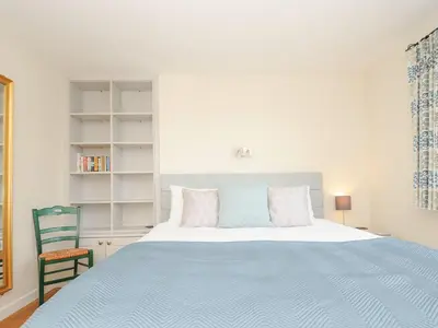 a bedroom with a large bed and a chair at Chimings in Wadebridge